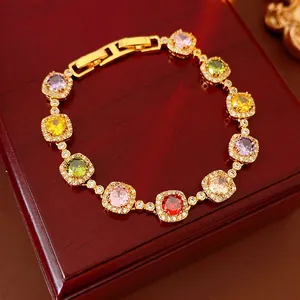 Vintage gold bracelet with multi-colored square zircons on a dark wood jewelry box