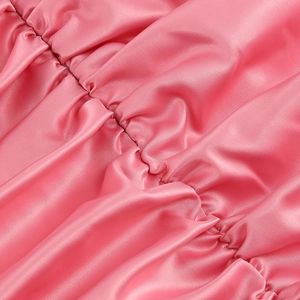 Détail du tissu en satin rose avec drapé élégant et texture soyeuse brillante