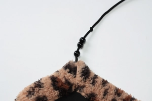 Vue macro du tissu léopard en fausse fourrure avec perles noires décoratives sur cordon