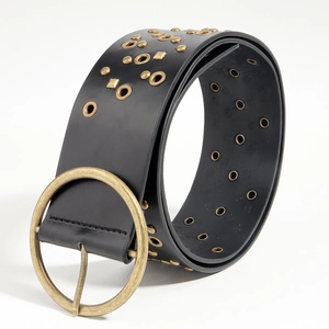 Detail of vintage black leather belt with antique brass buckle and rows of metal rivets