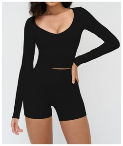 Détail de l'ensemble de sport noir avec haut court à manches longues et short de fitness