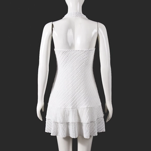 Gros plan sur la robe blanche dos nu avec texture diagonale et volants à double couche