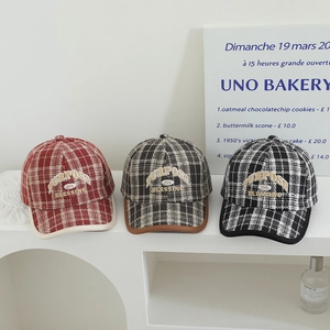 Close-up of vintage plaid baseball caps with embroidered letters and textured wool fabric