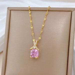Detail of gold necklace featuring a square pink gemstone pendant with micro-inlaid diamonds