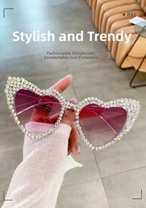 Dettaglio degli occhiali da sole a cuore con strass e lenti viola sfumate