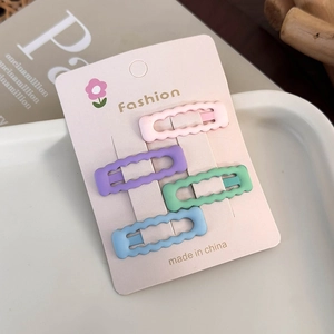 Set of four colorful wavy hair clips in pink purple green and blue on floral card
