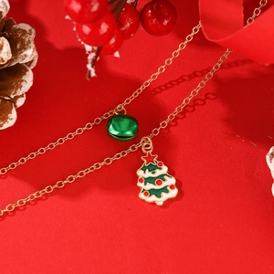 Collar de Navidad con árbol de esmalte colorido y campana verde en fondo rojo festivo