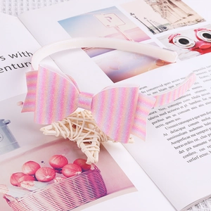 Gros plan d'un serre-tête à nœud rose pailleté rayé sur fond de magazine de mode chic