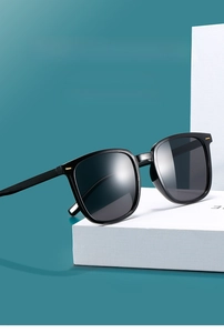 Detail of black square frame sunglasses with golden metal accents on temple hinges