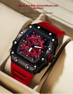 Close-up of black tonneau watch with red samurai relief dial and silicone strap