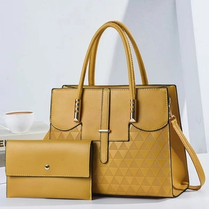Detail of yellow PU leather handbag with geometric triangle pattern and gold hardware
