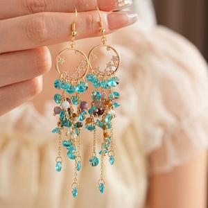 Detail of vintage star tassel earrings featuring colorful crystal beads and gold hooks