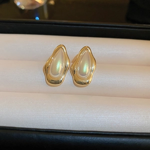 Dettaglio degli orecchini vintage in oro con inserti in madreperla dai riflessi iridati