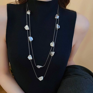 Dettaglio della collana a doppio strato con ciondoli geometrici irregolari in argento