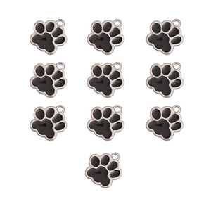 Macro detail of ten rose gold paw print charms with black enamel for DIY jewelry making