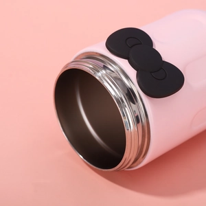 Detail of cute pink vacuum flask with wide mouth opening and black bow decoration