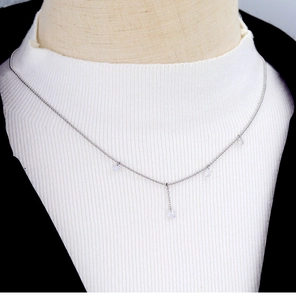 Elegant silver Y-shaped necklace with clear square and teardrop crystal pendants on a model