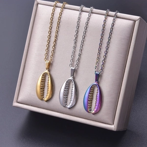 Three shell pendant necklaces in gold silver and rainbow colors on a display tray