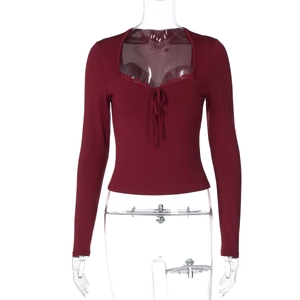 Détail d'un haut en maille bordeaux avec décolleté en cœur et bordure en dentelle fine
