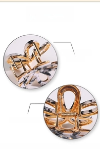 Detailed view of black and white marble hair claw clip with golden heavy-duty spring