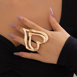 Detailed view of oversized chunky gold metal heart ring worn on finger