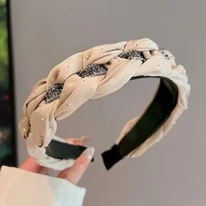 Handwoven beige headband with shimmering rhinestones and elegant braided fabric design