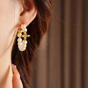 Detail showing vintage 18K gold plated earring with pearl hoop and clover charm