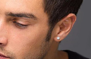 Close-up of a men's titanium steel stud earring with a brilliant six-prong set zircon