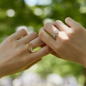 Close-up of gold and silver S925 sterling silver heart rings with zircon inlay on hands