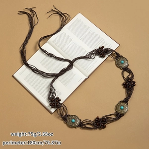 Détail d'une ceinture bohème tressée avec perles en bois sur pages de livre ancien