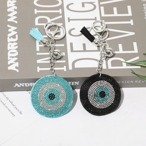 Detail of blue and black evil eye keychains with sparkling rhinestones and tassels