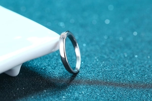 Macro shot of 925 silver eternity ring with princess cut stones on white ceramic