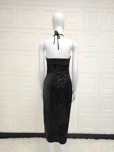 Detail of black sequined halter dress showing backless design on white mannequin