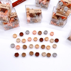 Close-up of daisy hair claws in Morandi colors displayed in a clear gift box