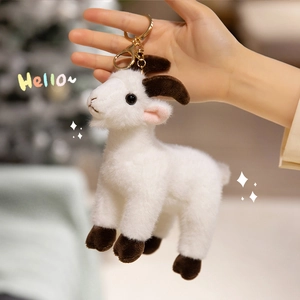 Cute white plush goat keychain accessory with golden clip shown in hand for bags