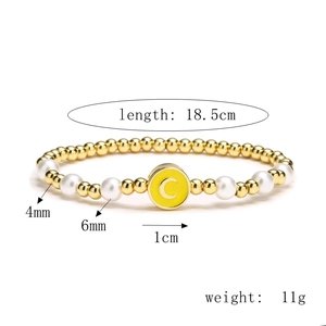 Détail du bracelet avec billes dorées, perles et pendentif émail jaune, longueur 18,5 cm