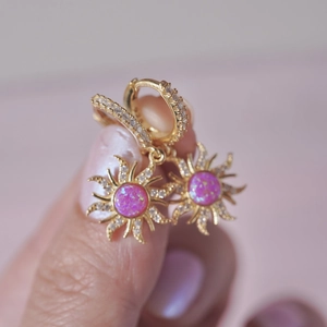 Close-up of gold sunflower earrings with pink opal and zircon pavé accents