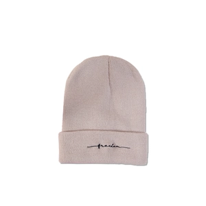 Détail du bonnet en maille rose pâle avec broderie freedom noire sur le bord replié
