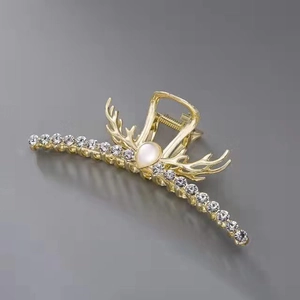 Detail of golden hair claw with reindeer antler design and sparkling crystal inlays