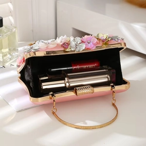 Detail of pink floral evening clutch showing interior capacity for lipstick and perfume