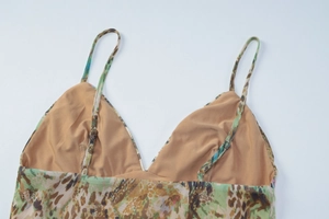 Detail of adjustable thin straps and V-neckline on printed lace mesh camisole top