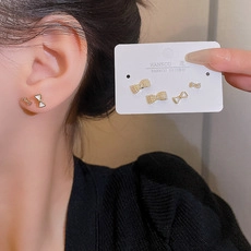 Detailed view of 925 silver needle bow earrings with zircon and pearl accents