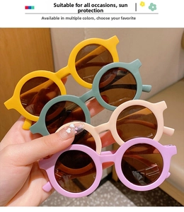 Detail shot of round matte plastic children's sunglasses in yellow, green, and beige