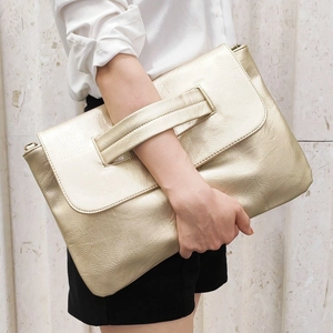 Detailed close-up of champagne gold large PU clutch with textured pleated finish and handle