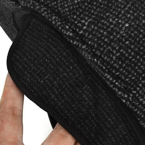 Detailed close-up of dark grey woven fabric and black trim on a warm outdoor cap