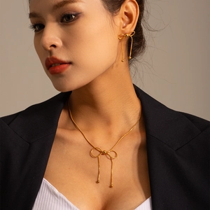 Elegant gold bowknot necklace and earrings set worn by model for a vintage look