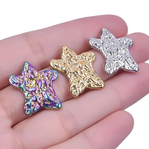 Detailed view of three-piece star earrings in iridescent, gold, and silver finishes