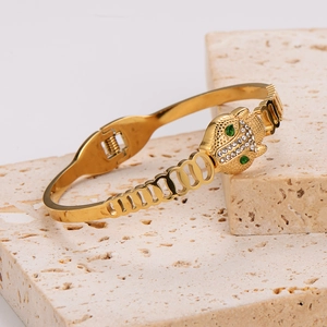 Retro stainless steel leopard head bangle with gold plating and cubic zirconia stones
