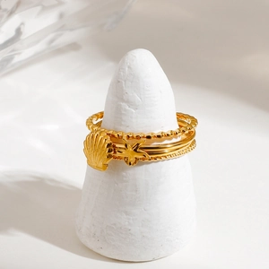 Ocean style gold shell and starfish ring set on a jewelry display stand
