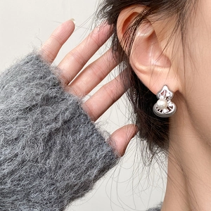 Close-up of model wearing silver hollow gourd earrings with pearl and zircon inlay
